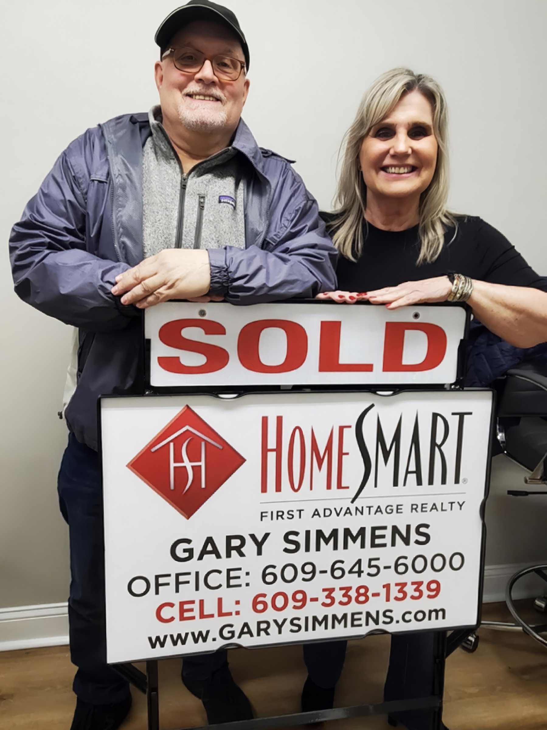 Gary's clients with their HomeSmart SOLD sign
